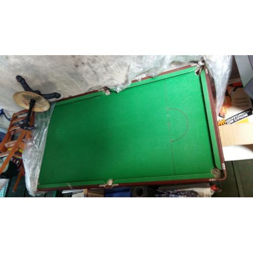 pool table with cue sticks and pool balls