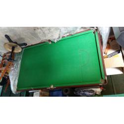 pool table with cue sticks and pool balls