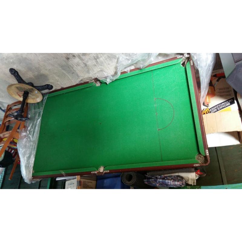 pool table with cue sticks and pool balls