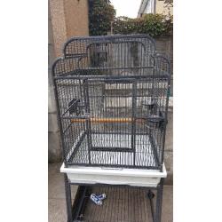 Black metal birdcage on stand with shelf