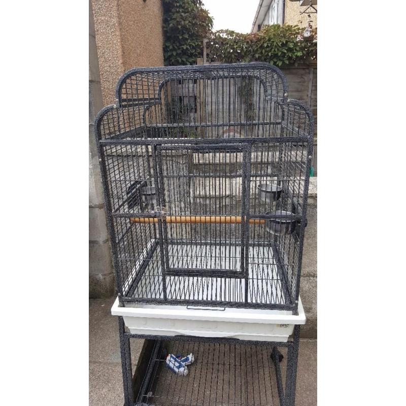 Black metal birdcage on stand with shelf