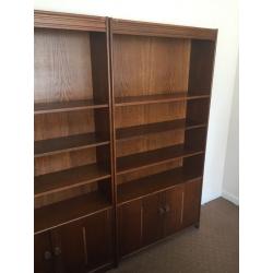 Two oak veneer bookcases with cupboards