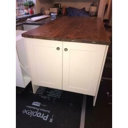 Cream shaker style kitchen island with cupboards and solid wood top