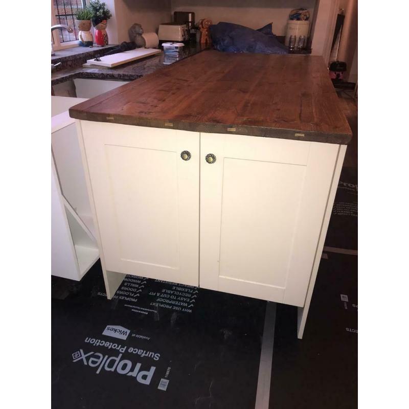 Cream shaker style kitchen island with cupboards and solid wood top