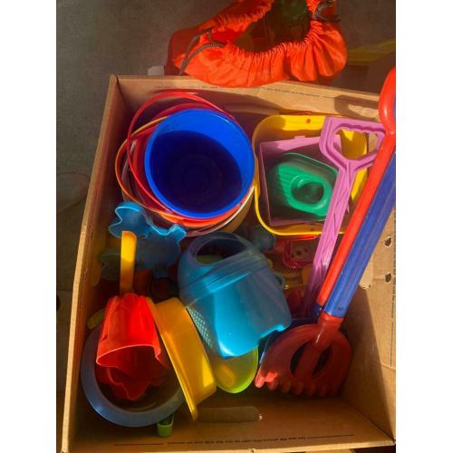 Box and bag overflowing with garden/ beach / seaside / water park toys