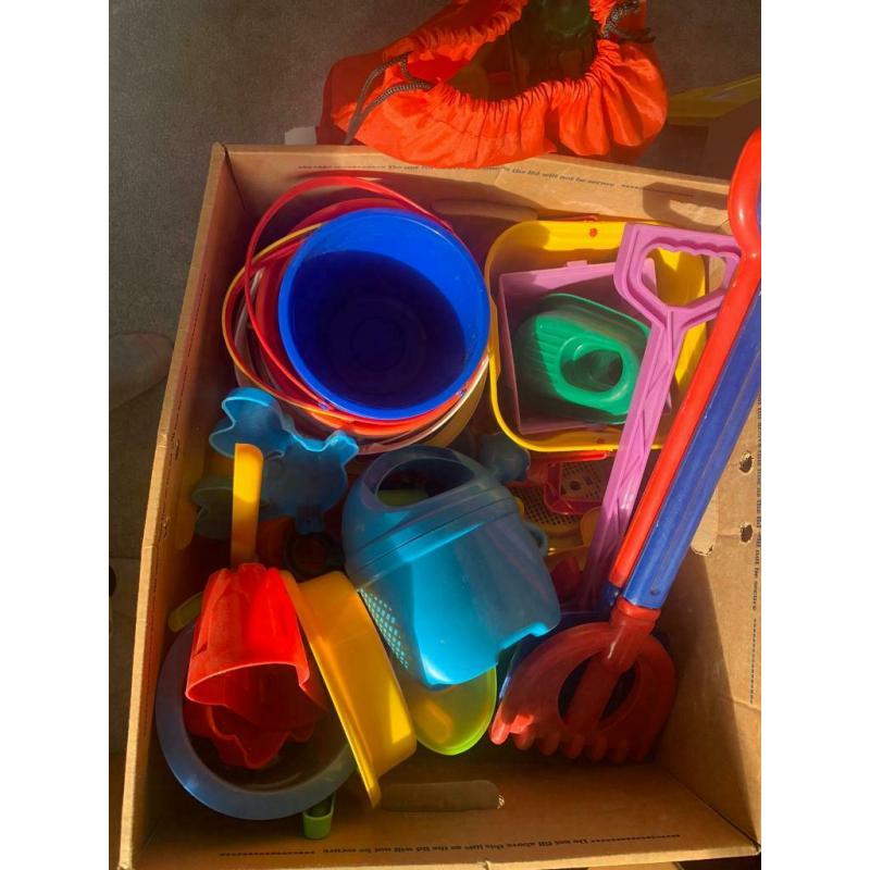 Box and bag overflowing with garden/ beach / seaside / water park toys